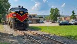 CVSR 6773 and train pass behind the eateries and shops.